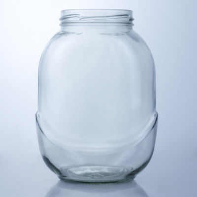 Un bocal de verre rond clair pour la manipulation de la surface décale dans une solution de production alimentaire