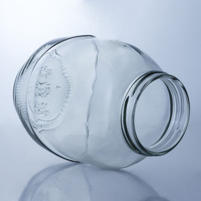 Un bocal de verre rond clair pour la manipulation de la surface décale dans une solution de production alimentaire