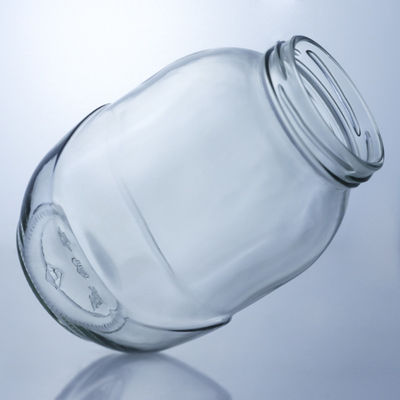 Un bocal de verre rond clair pour la manipulation de la surface décale dans une solution de production alimentaire