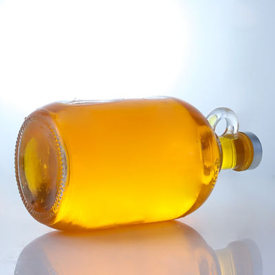 Bouteille en verre de liqueur de forme ronde avec poignée et bouchon à vis