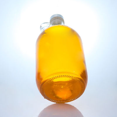 Bouteille en verre de liqueur de forme ronde avec poignée et bouchon à vis