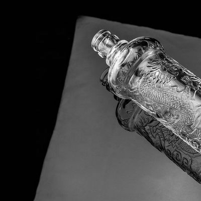 Belle bouteille en verre en relief de dragon avec couvercle en or Logo personnalisé et base en verre
